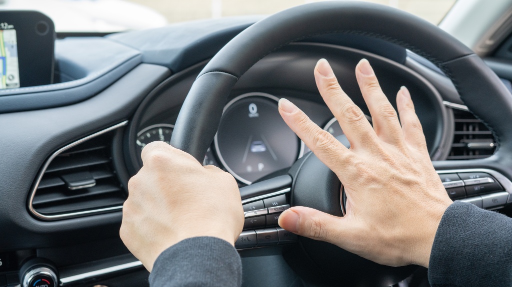 A person who honks a car horn